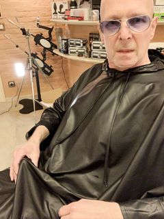 Lenny52, seduto nudo sulla poltrona di pelle nera della sua scrivania, ha indossato l'abito sintetico del parrucchiere.