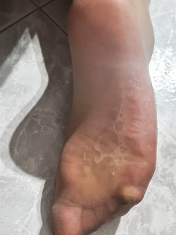 Mostro il mio culo e gambe in calze e i miei piedi sborrati